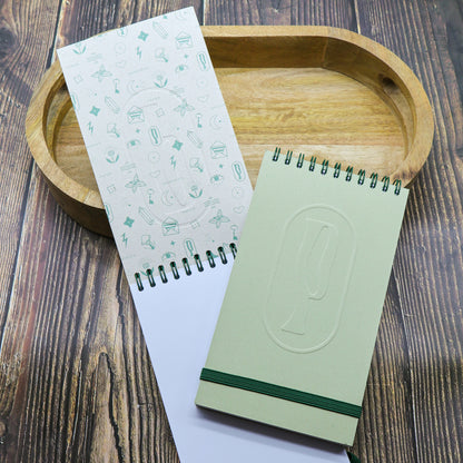 Colombo di Piperita Paper: taccuino tascabile 10x17 cm, pagine bianche, copertina verde e sabbia con rilievo e spirale, perfetto per appunti e idee.