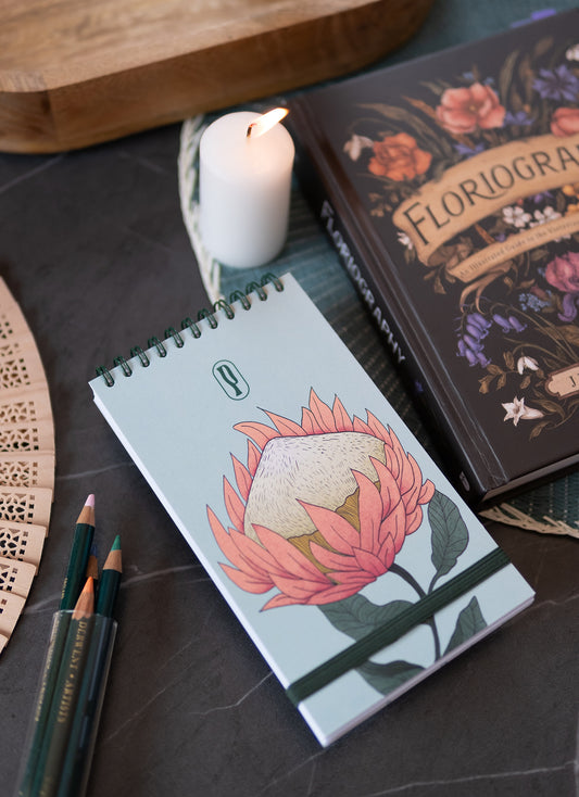 Colombo Protea di Piperita Paper: taccuino tascabile 10x17 cm, pagine bianche, copertina con stampa floreale e spirale, perfetto per appunti e idee creative.