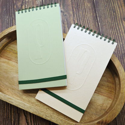 Colombo di Piperita Paper: taccuino tascabile 10x17 cm, pagine bianche, copertina verde e sabbia con rilievo e spirale, perfetto per appunti e idee.