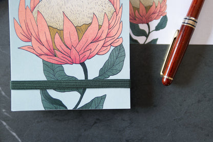 Colombo Protea di Piperita Paper: taccuino tascabile 10x17 cm, pagine bianche, copertina con stampa floreale e spirale, perfetto per appunti e idee creative.